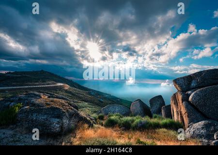 Serra Da Estrela natural park mountains in the Northern Portugal. Mountains at sunset. Sunlight through clouds.  Stock Photo