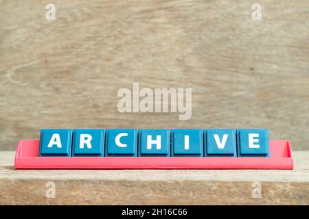 Tile alphabet letter with word archive in red color rack on wood background Stock Photo