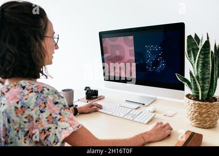 From above of female designer using contemporary computer while working in modern office Stock Photo