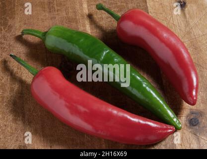 three hot peppers on wooden background Stock Photo