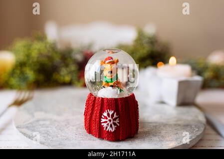 Decorative snow globe on the plate on the christmas table Stock Photo