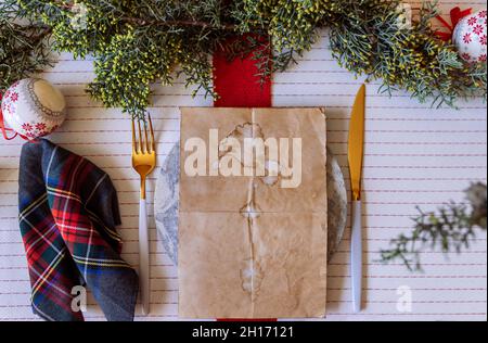 From above red holiday place setting with empty menu on white tablecloth Stock Photo