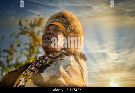 elder woman from southern Africa dressed in a traditional costume with a hat and cow hide in a village in the rural area Stock Photo