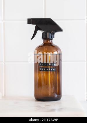 Zero waste home cleaning concept. Amber bottle with washing solution on marble shelf. Various items and ingredients for eco home cleaning. Front view Stock Photo