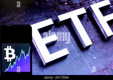In this Photo illustration a Bitcoin logo seen displayed on a smartphone with an ETF(exchange traded fund) logo in the background Stock Photo