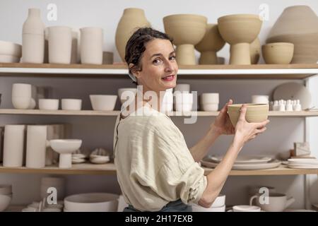 Ceramist woman holding a potter in her studio Stock Photo