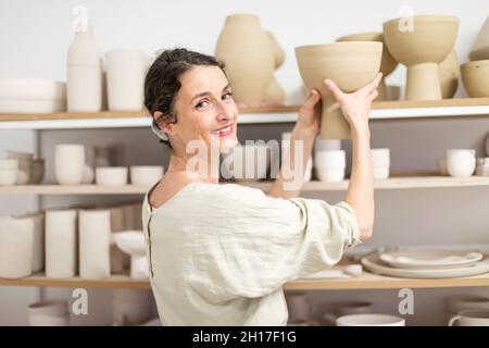Ceramist woman holding a potter in her studio Stock Photo