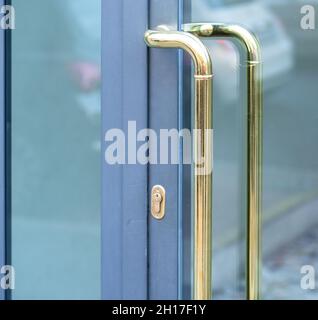 entrance door with polished brass handle reflected in the window Stock Photo