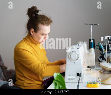 Female seamstress using sewing machine while working at home Stock Photo
