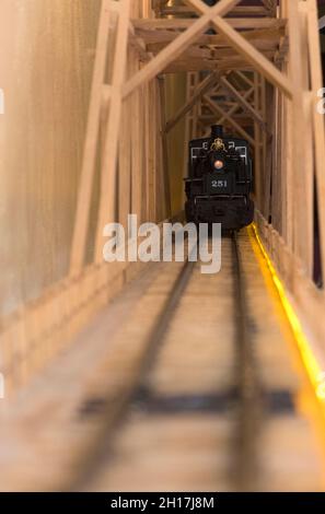 A Black model Locomotive on track layout with headlamp Stock Photo