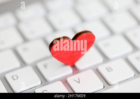 Small red heart on computer keyboard closeup Stock Photo