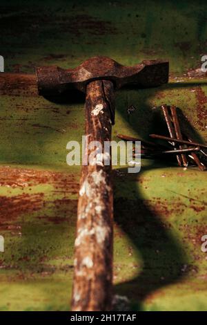 Old rusty hammer and nails on a corrugated iron background Stock Photo
