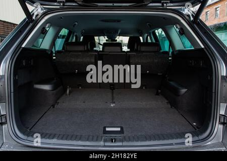 Huge, clean and empty car trunk in interior of a modern compact suv. Rear view of a SUV car with open trunk. Car trunk interior. Stock Photo