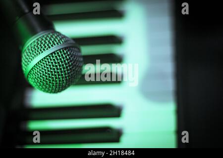 Microphone over piano keys in dim light. No people Stock Photo