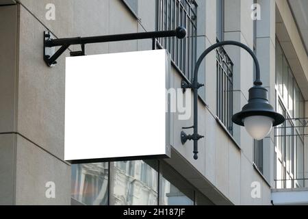 Mock up. Blank white rectangular shape signboard on the wall outdoors. Signage of shop, store, cafe, restaurant Stock Photo