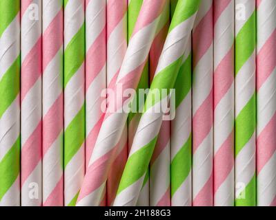 Bright striped cocktail paper straws background. Macro texture of disposable pink green drinking tubes. Ecologically friendly colorful straws. Stock Photo