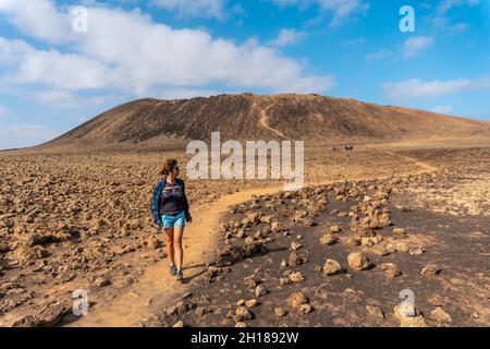 A young woman on the trail to the Crater of the Calderon Hondo volcano near Corralejo, the island of Fuerteventura, Canary Islands, Spain Stock Photo