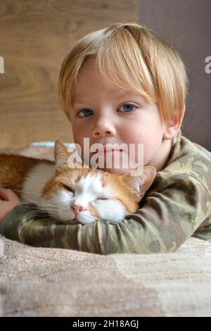 Portrait of a child aged four years old whit sleeping red cat Stock Photo