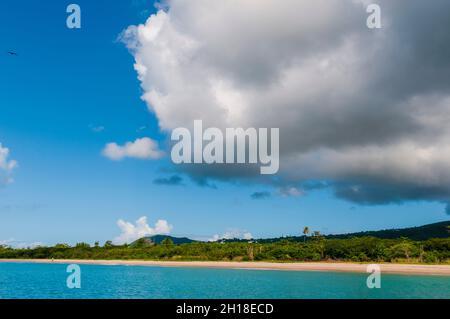 A large cloud hangs low above Pinney's white sand beach. Nevis Island, West Indies. Stock Photo