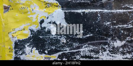 Old black and yellow grunge ripped torn collage posters creased crumpled paper placard texture background Stock Photo