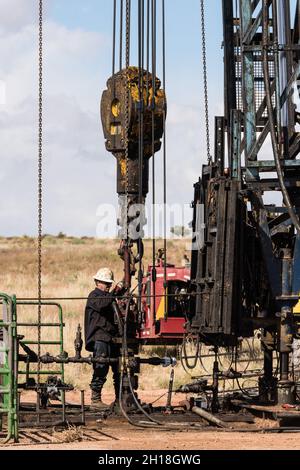 The well service crew on a workover rig works on an oil well to try to bring it back into service. Stock Photo