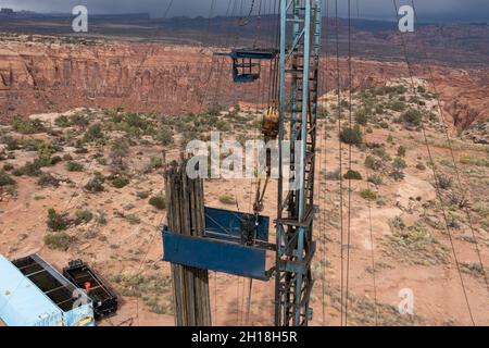 A derrickman attaches tubing to the traveling block on a workover rig doing maintenance on an oil well. Stock Photo