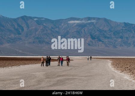 Tourists walk on salt pans in Badwater Basin. Death Valley National Park, California, USA. Stock Photo