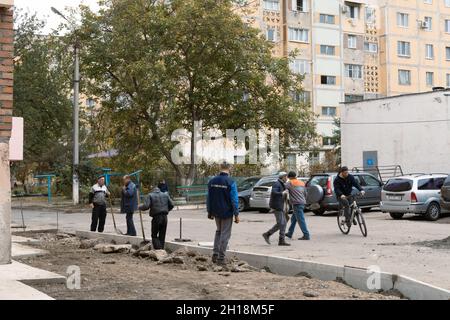 Tiraspol, Moldova - October 15, 2021: Road service workers install new concrete curbs in the courtyard of an apartment building in the capital of the Stock Photo