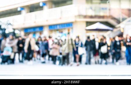 Blurred defocused abstract background of people walking on street - Crowded city center at rush hour in urban area over zebra crossing Stock Photo