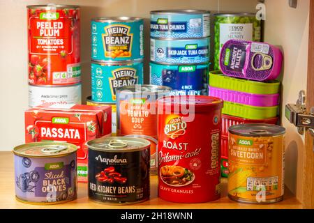 Tinned or canned foodstuffs in a UK kitchen cupboard, stocked up, storage, provisions Stock Photo