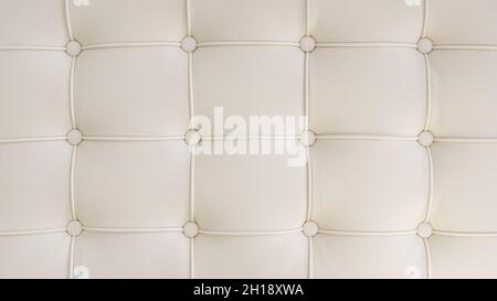 Tufted white leather background with copy space as interior design inspiration, symmetrical and aesthetically pleasing pattern formed by round buttons Stock Photo
