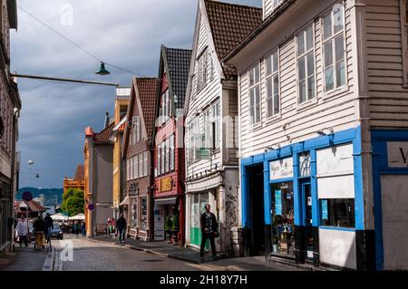 Pedestrians walk past brightly painted shops on Kong Oscars Gate, one of Bergen's oldest streets. Bergen, Norway Stock Photo