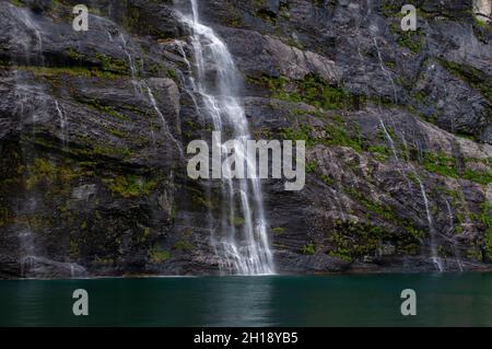 Seven Sisters waterfalls plunges off sheer cliffs into Geirangerfjord. Geirangerfjord, Norway. Stock Photo