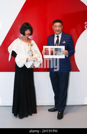 Manhattan Beach, California, USA. 15th October, 2021. Homeira Goldstein, Chairman of the Board of the Manhattan Beach Art Center, with her Los Angeles Beverly Arts (LABA) Icon Charity Award presented by TV host Joey Zhou holding her gift of a book by LABA Blue-chip artist Jiannan Huang, at the TIME4ART Exhibition featuring artist David A. Peters at the Manhattan Beach Art Center in Manhattan Beach, California.  Credit: Sheri Determan Stock Photo