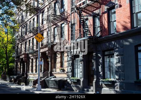 Sunlight shines on a block of historic buildings on Leroy Street in the West Village neighborhood of Manhattan in New York City NYC Stock Photo