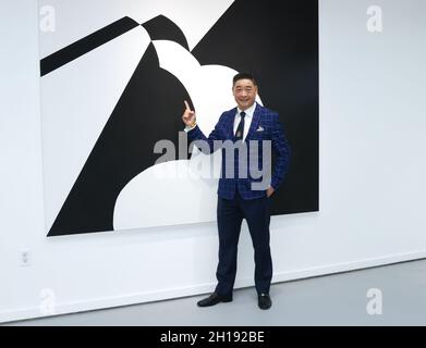 Manhattan Beach, California, USA. 15th October, 2021. TV host Joey Zhou points to artwork by David A. Peters at the TIME4ART Exhibition featuring artist David A. Peters at the Manhattan Beach Art Center in Manhattan Beach, California.  Credit: Sheri Determan Stock Photo