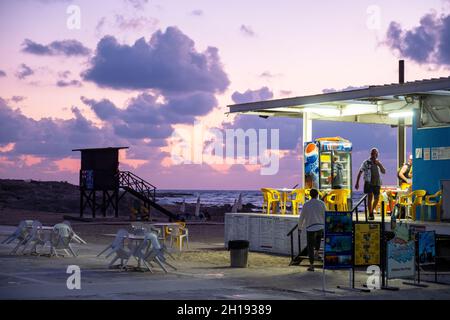 Paphos Lighthouse beach cafe at dusk, Paphos, Cyprus. Stock Photo