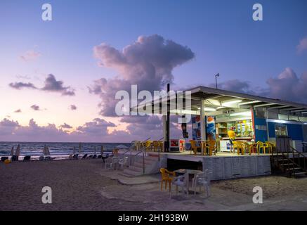 Paphos Lighthouse beach cafe at dusk, Paphos, Cyprus. Stock Photo