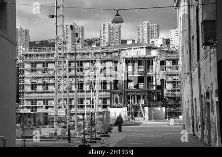 Black and white photo with cranes and ruined public building construction. Urban street in the city Stock Photo