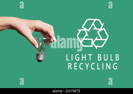 A person throwing light bulb for recycling. Hand throws used light bulb into garbage. Concept of sorting, recycling Stock Photo