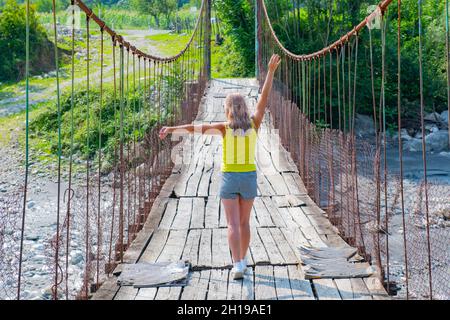 one woman stands on a suspension bridge in Georgia Stock Photo