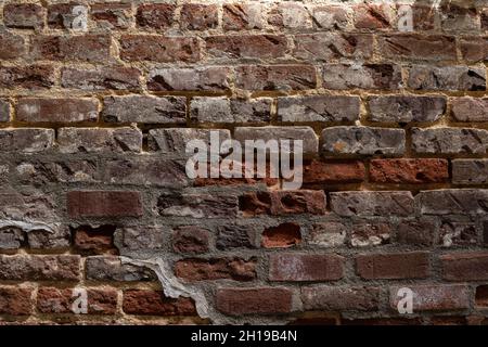 Red brick wall with numerous levels of  decay and repair, horizontal aspect Stock Photo