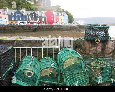 Scottish tourism in the Highlands & Islands: picturesque scene of lobster pots in the harbour and the row of bright painted houses at Tobermory, Mull Stock Photo