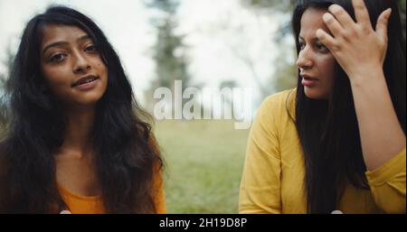 A discussion of Indian girlfriends sitting in a garden surrounded by