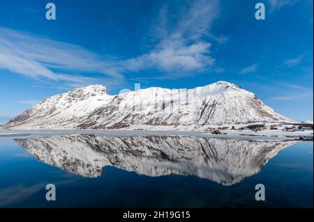 Mountains reflected into calm water of Knutstad Bay. Knutstad, Lofoten Islands, Nordland, Norway. Stock Photo