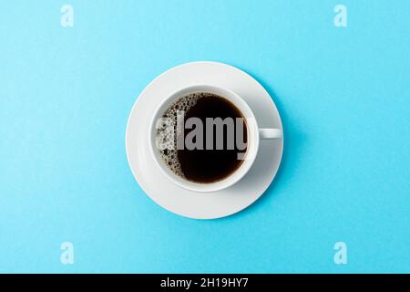 Cup of coffee on blue background. Minimal food concept. Top view. Stock Photo