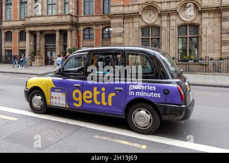 Black taxi cab advertising rapid delivery service Getir, London England United Kingdom UK Stock Photo