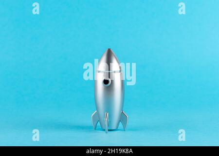 Creative composition with silver rocket on pastel blue background. Minimal holiday concept. Stock Photo