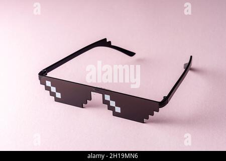 Meme Pixel glasses on pink background. Minimal concept. Stock Photo
