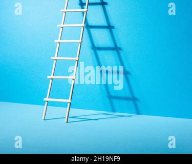 Stepladder on blue background. Success and progress concept. Minimal composition. Stock Photo